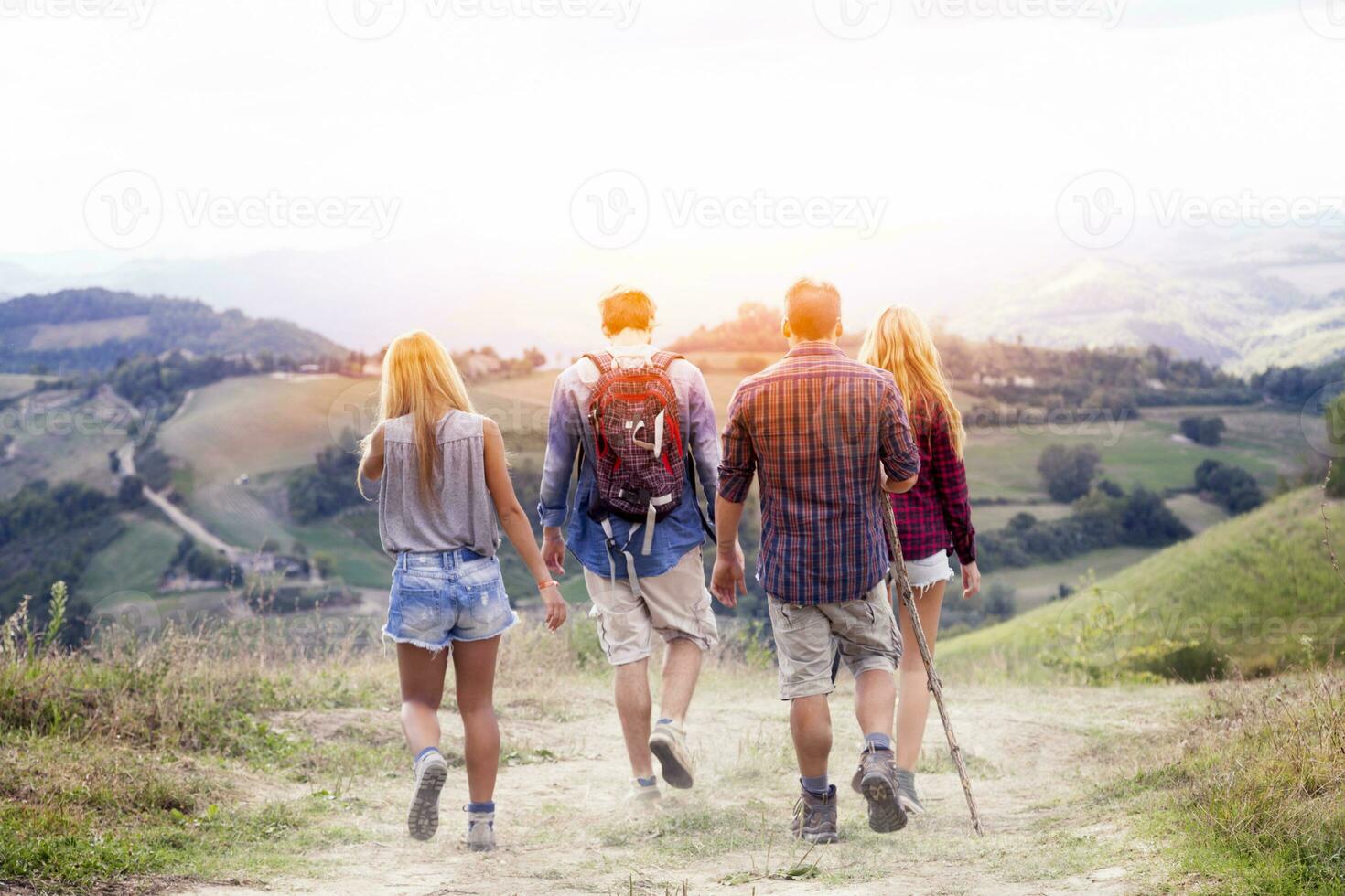 groep van jong wandelaars wandelen richting de horizon over- de berg foto