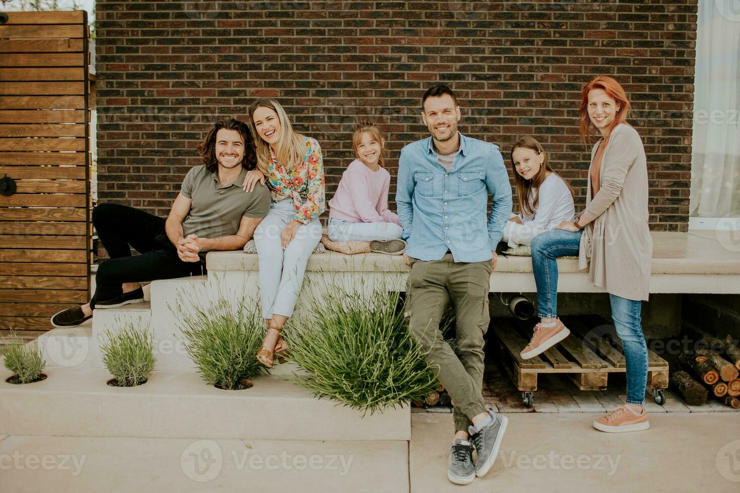 groep van jong mensen en kinderen hebben mooi zo tijd in de huis achtertuin foto