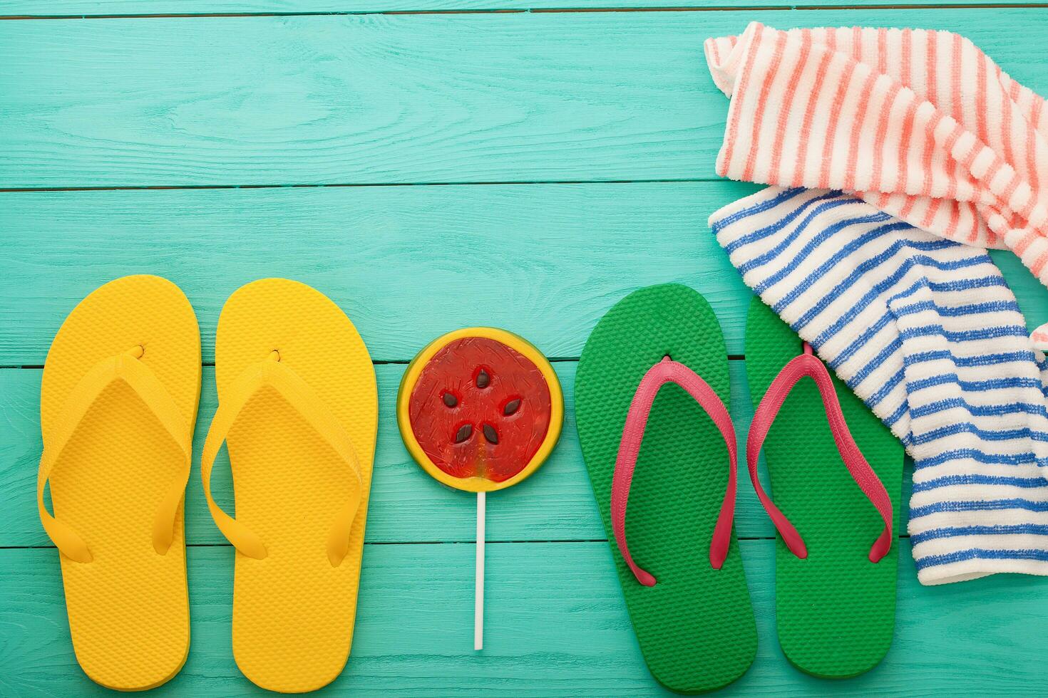 omdraaien flops, watermeloen snoep en handdoek. zomer strand accessoires en kopiëren ruimte Aan blauw houten achtergrond. top visie foto