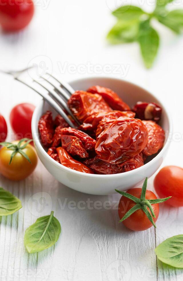 kom met zon droog tomaten met vers kruiden en specerijen. foto