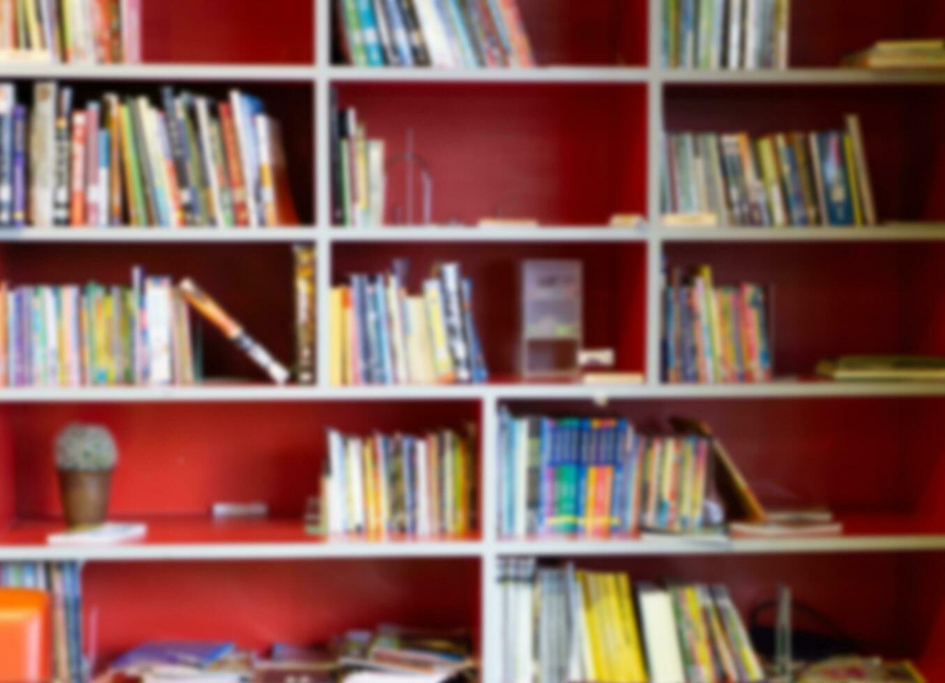 wazig rood boekenplank met veel boeken in bibliotheek voor onderwijs concept achtergrond foto