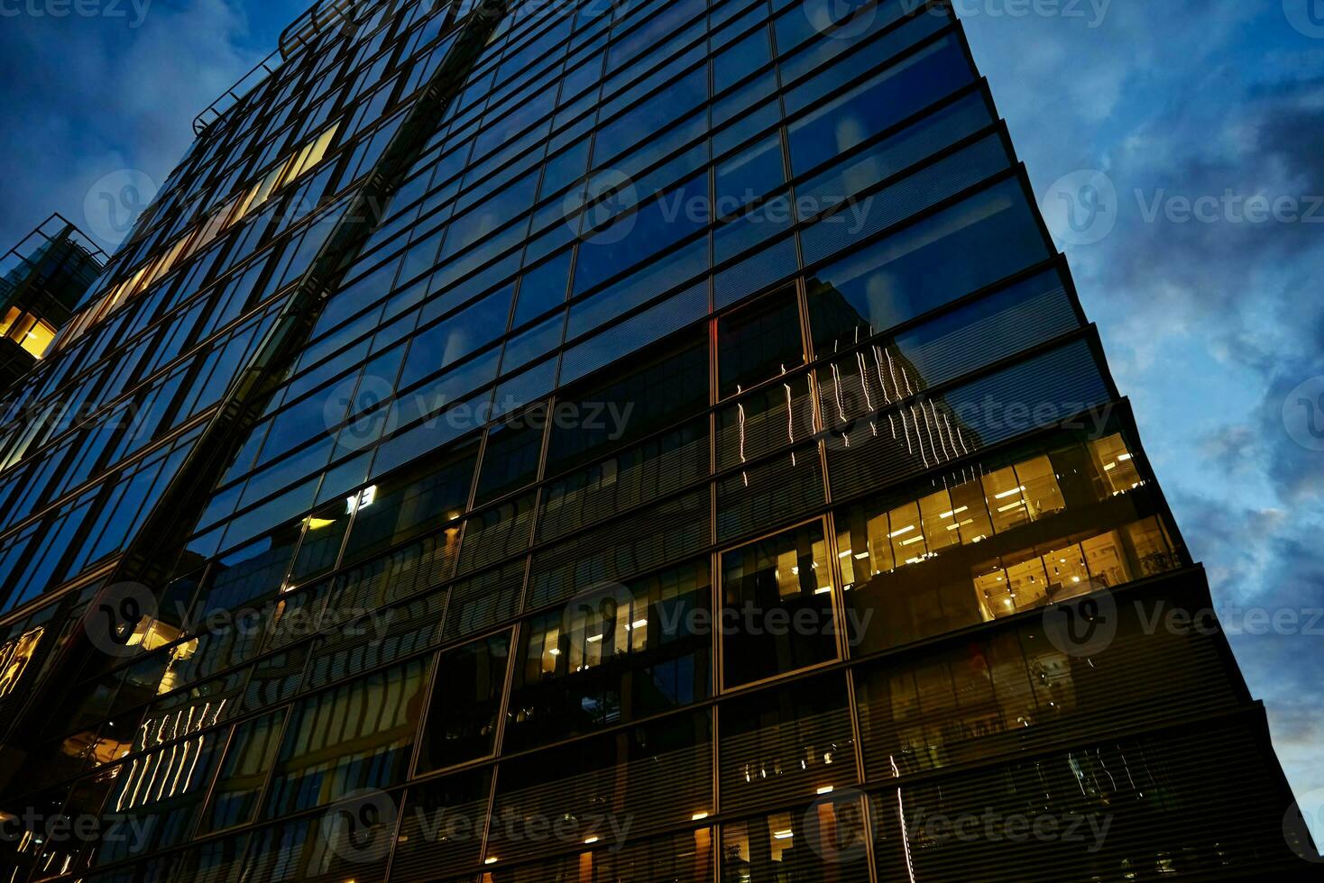 hoog stijgen kantoor gebouw met verlichte ramen Bij nacht foto