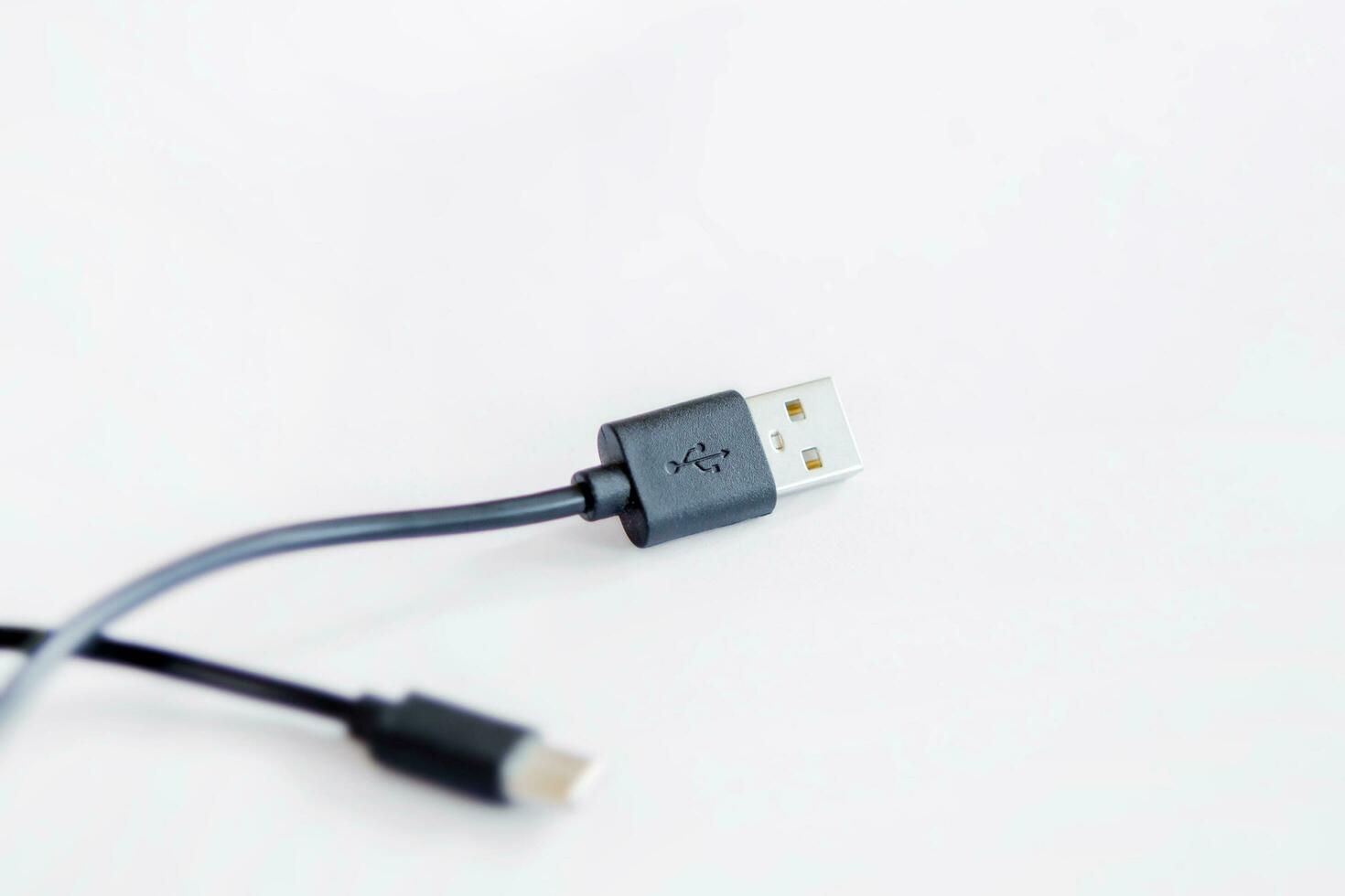 detailopname van zwart USB opladen kabel, verenigbaar voor veel apparaten, geïsoleerd Aan wit achtergrond. foto