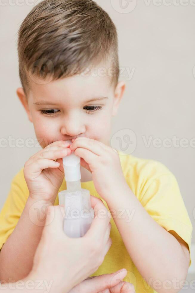 moeder behandelt bronchitis in een kind met een vernevelaar foto