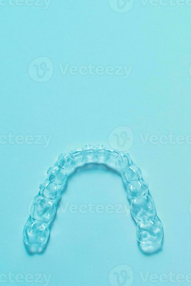 onzichtbaar tandheelkundig tanden haakjes tand aligners Aan turkoois achtergrond. plastic een beugel tandheelkunde vasthouders naar rechtzetten tanden. foto