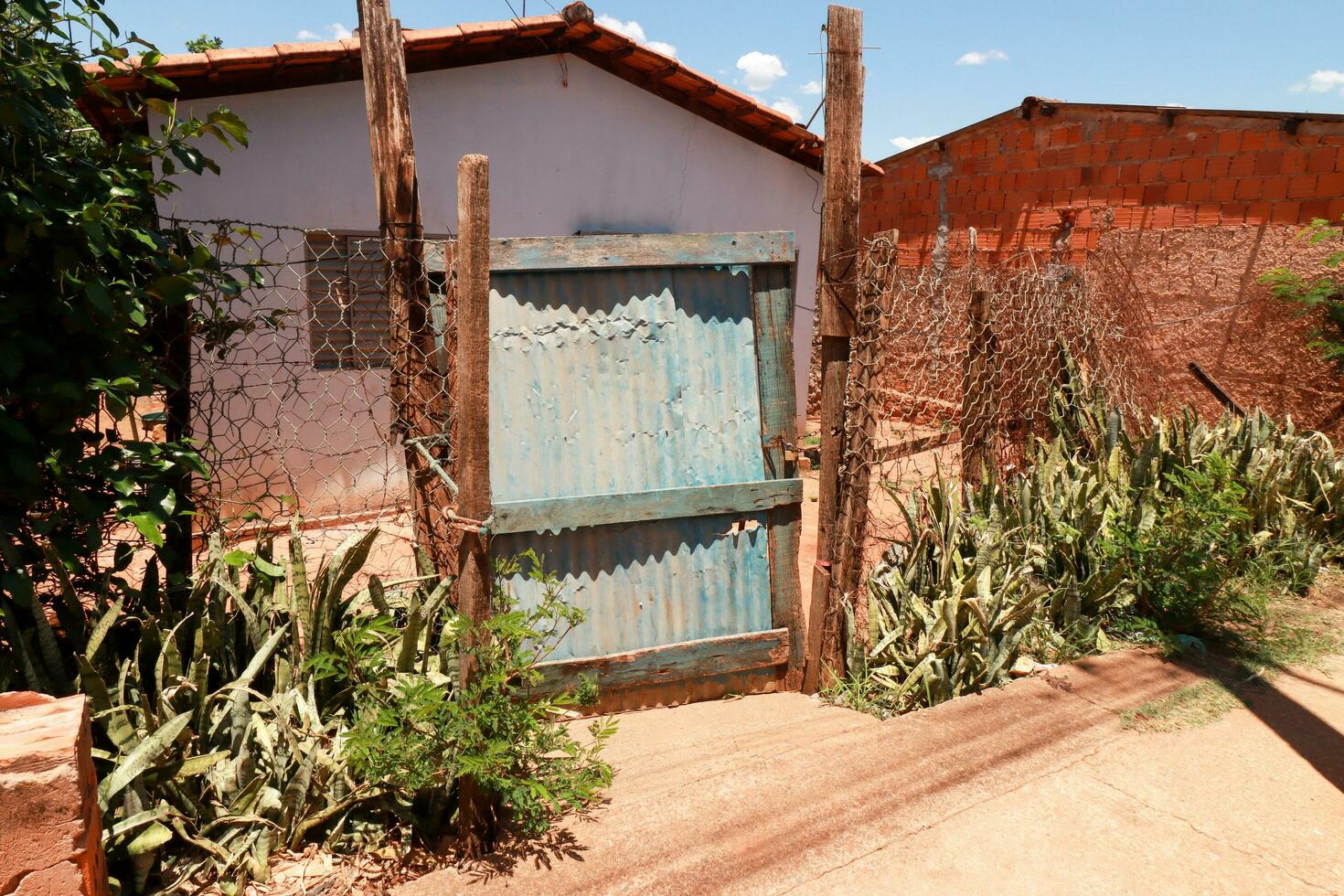 platina, goias, Brazilië november 11 2023 slecht gebouwd hek en poort naar een Ingang van een huis in platina, dat is in verval foto