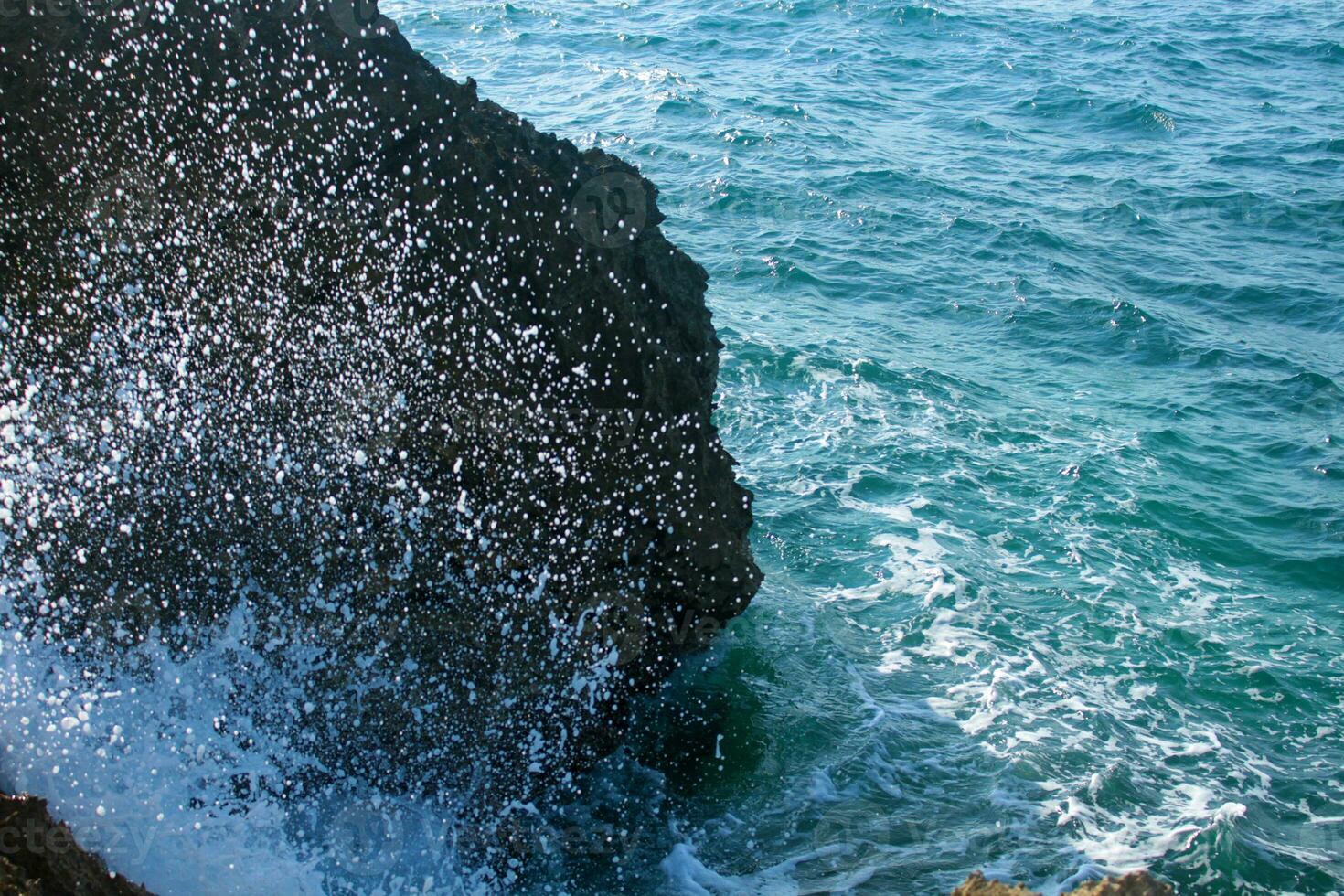 zee water plons Aan rotsachtig kust foto