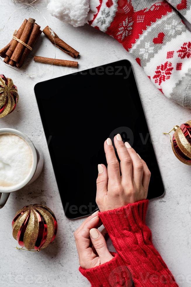 kerstdesktop met tablet omringd door koffie, kousen foto