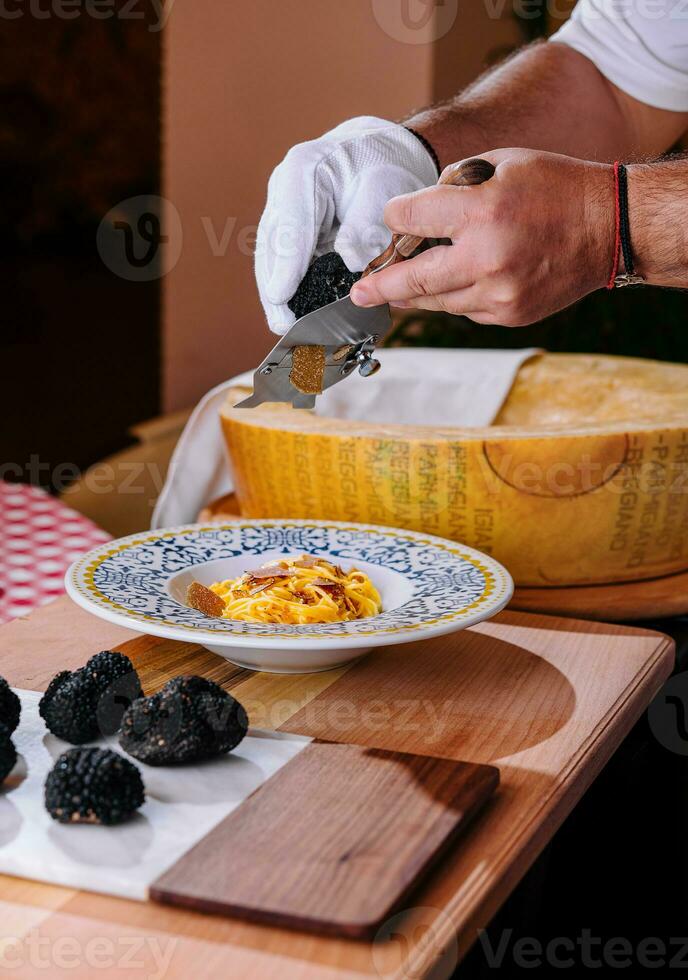 chef rooster truffel krullen Aan pasta met Parmezaanse kaas foto