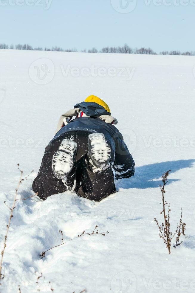 jongen gekleed hartelijk kruipen Aan de sneeuw foto