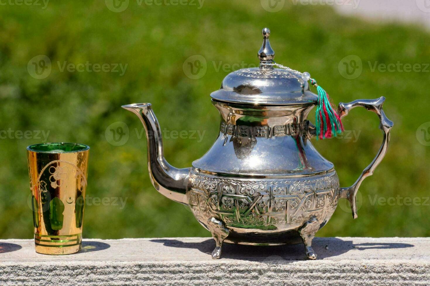 een zilver thee pot met een kleurrijk omgaan met foto