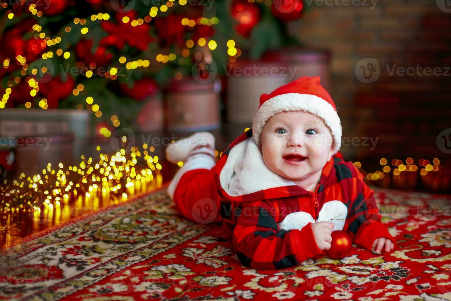 weinig zes maand oud baby gekleed net zo de kerstman claus. achtergrond voor Kerstmis kaart. de kind looks naar beneden Bij de plaats voor inscriptie. foto