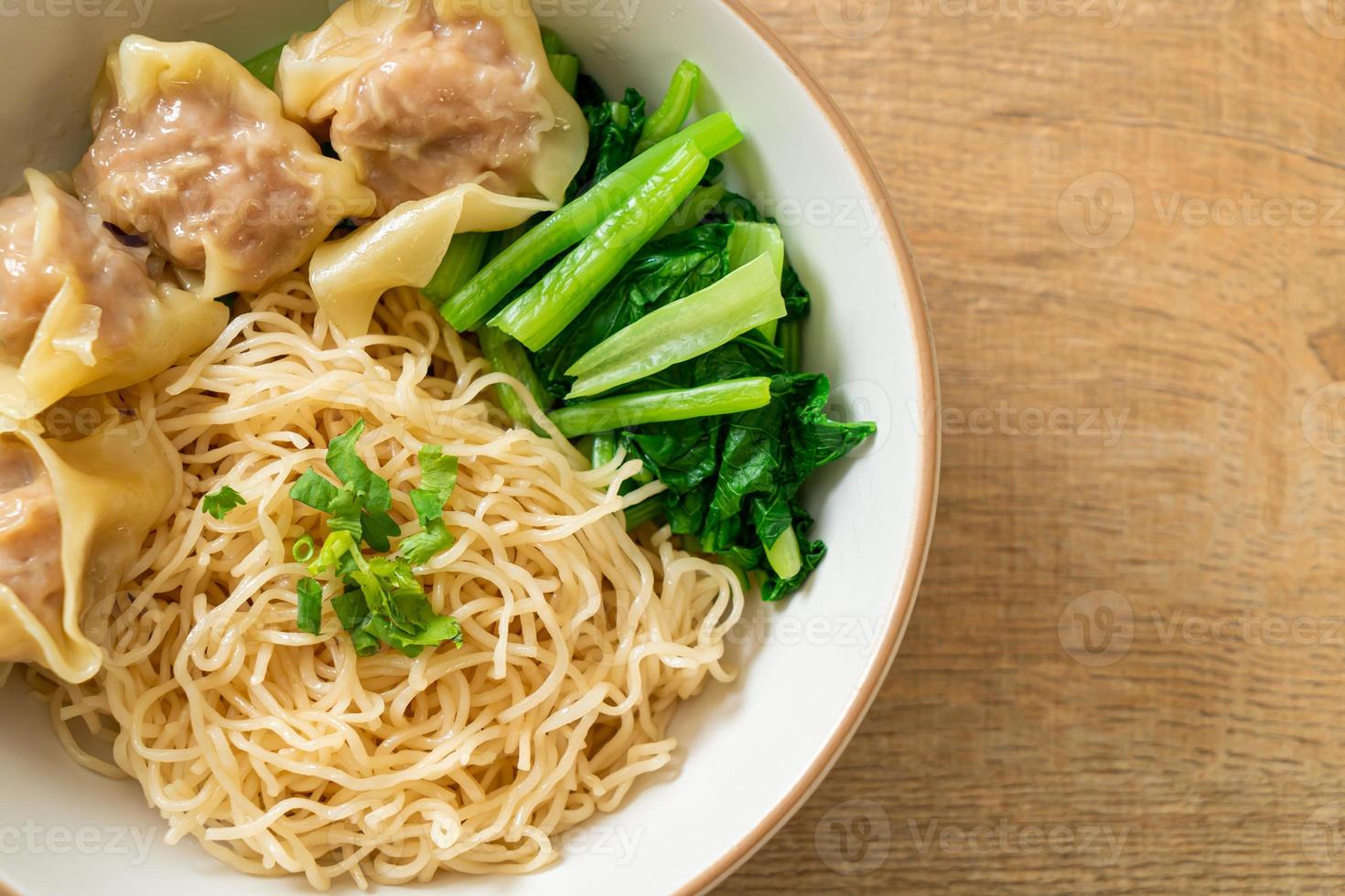 gedroogde eiernoedels met wonton van varkensvlees of dumplings van varkensvlees zonder soep foto