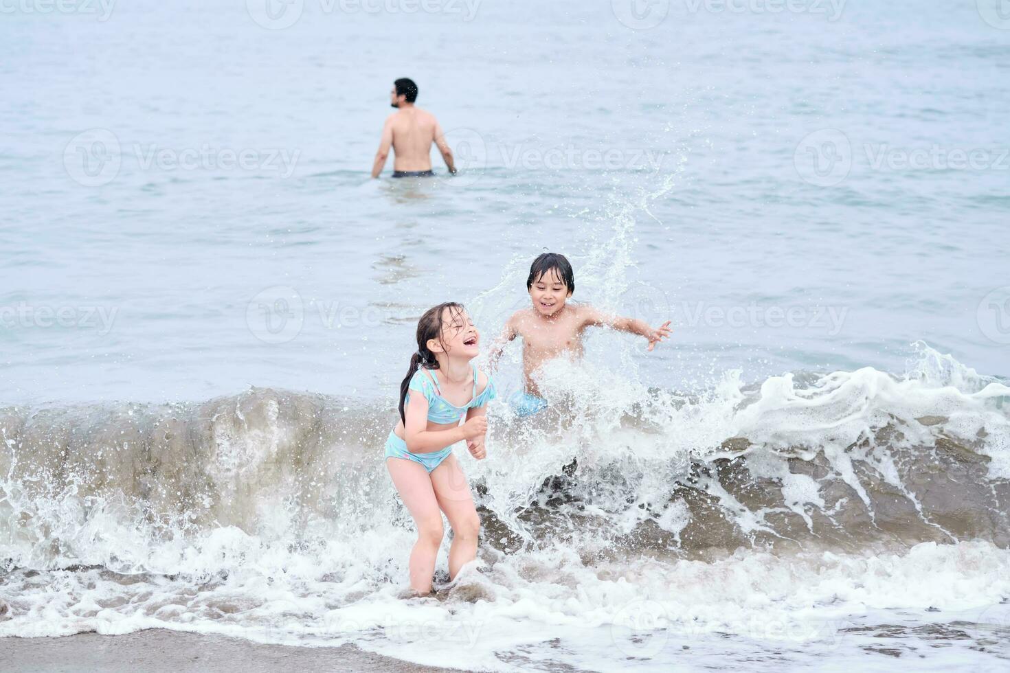 een jongen en een meisje zijn hebben pret spelen in de zee. foto