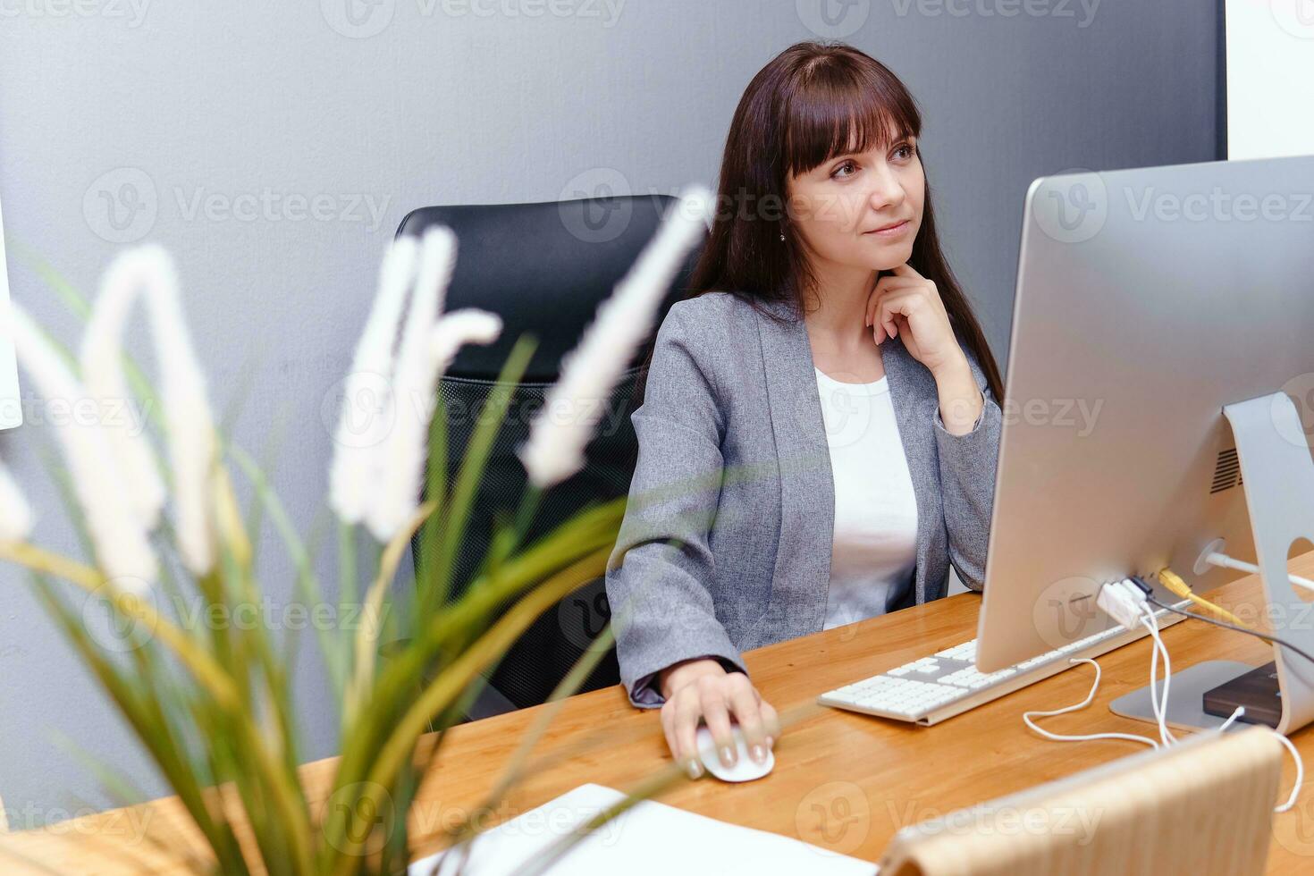 een brunette vrouw Bij een computer in de werkplek. bedrijf concept. foto