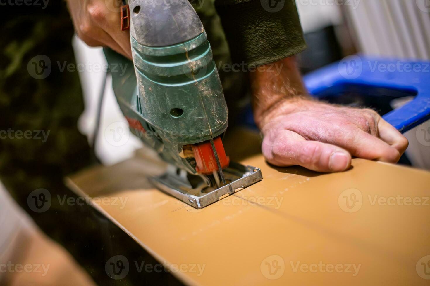 timmerman gebruik makend van een elektrisch decoupeerzaag naar bouwen een stuk van meubilair. de timmerman is gefocust en bepaald, en de decoupeerzaag is snijdend door de hout met gemak. foto