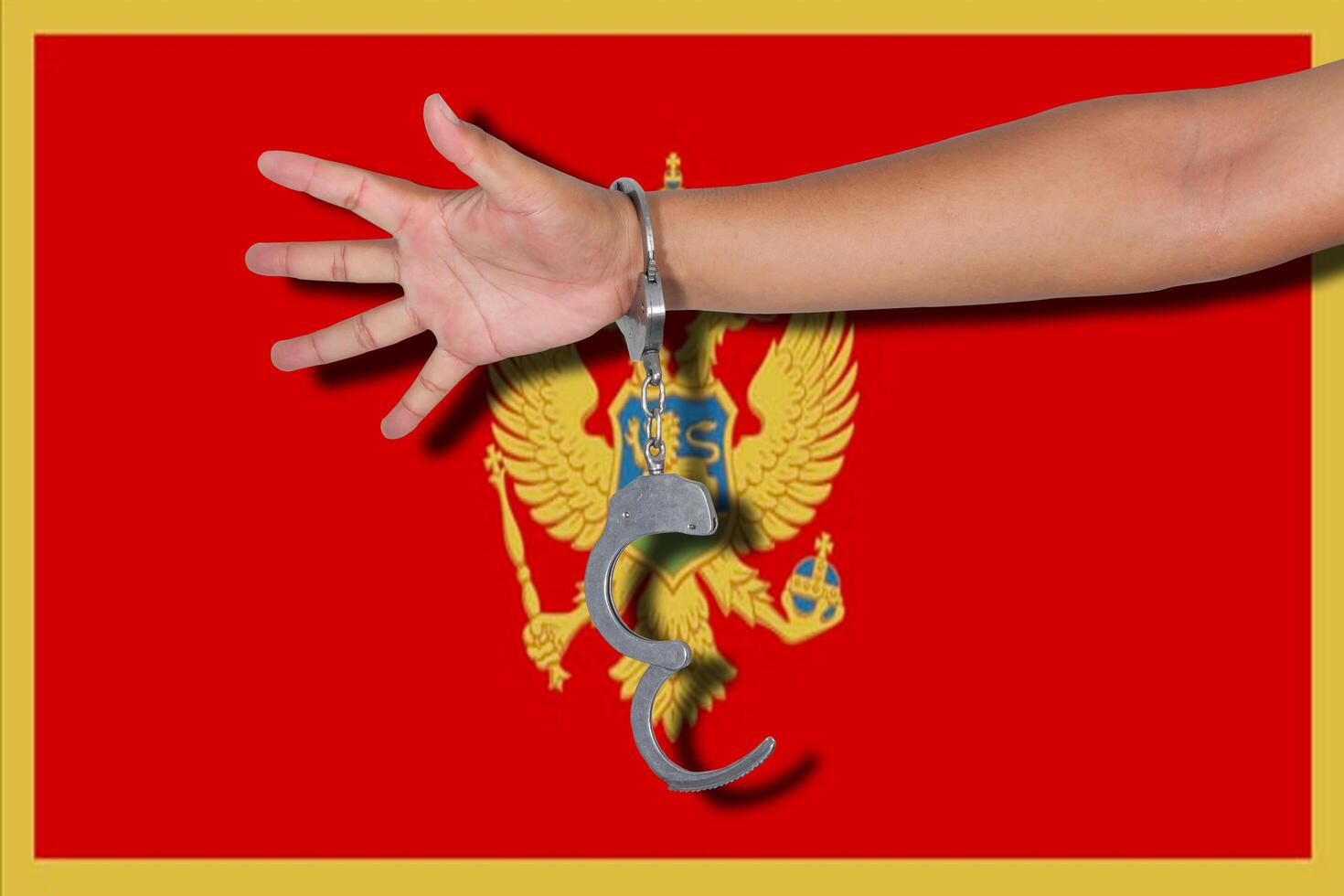 handboeien met hand op de vlag van Montenegro foto