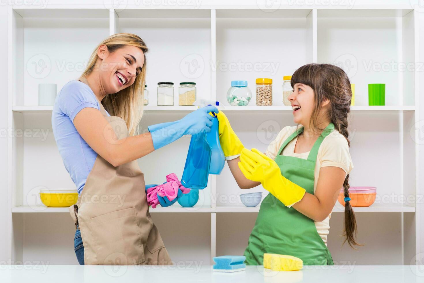 gelukkig moeder en haar dochter genieten schoonmaak en hebben pret samen. foto