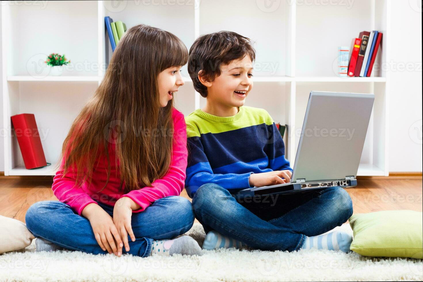 twee kinderen zittend Aan de verdieping met een laptop foto