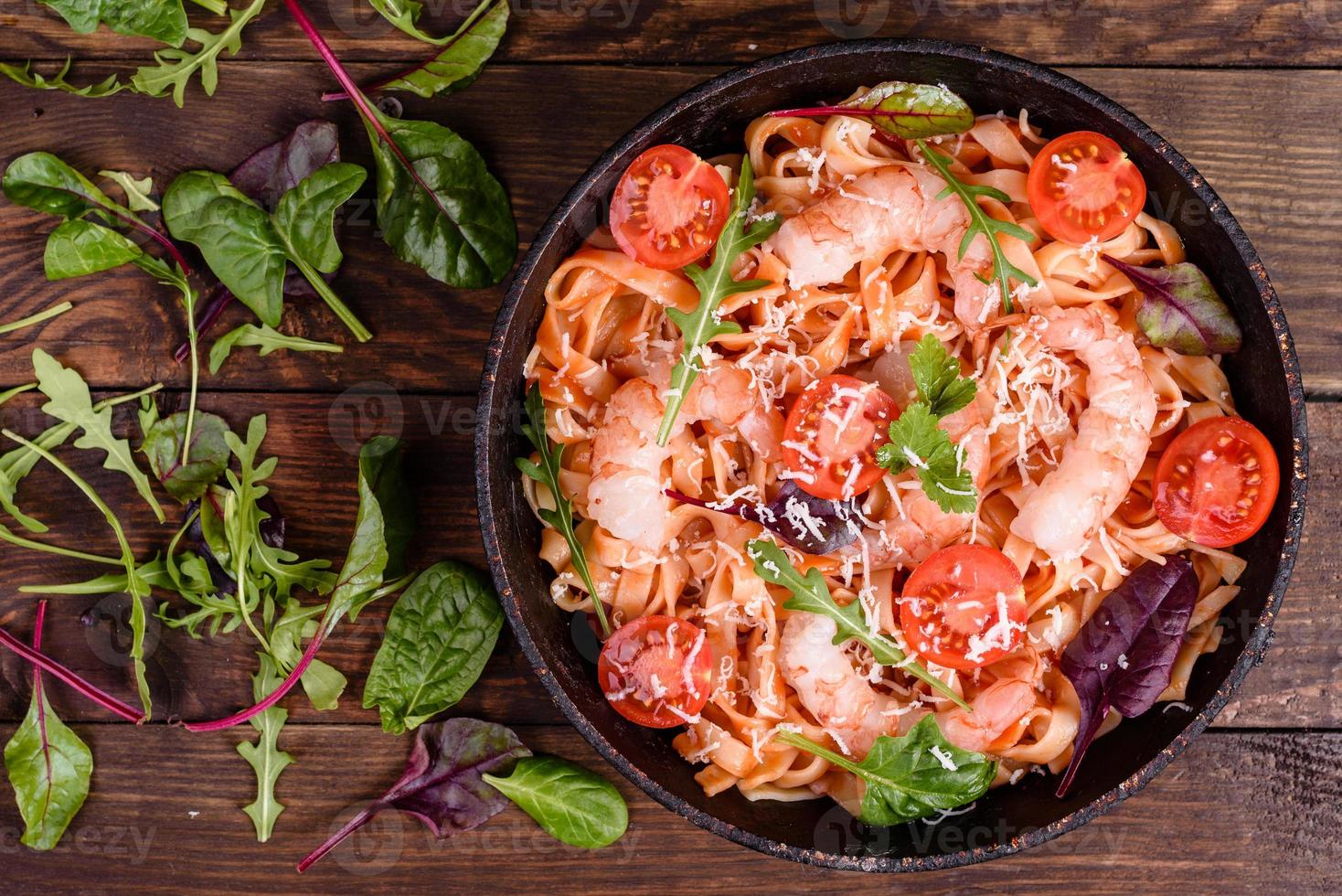 Lekkere pasta met garnalen en tomaat op een koekenpan foto