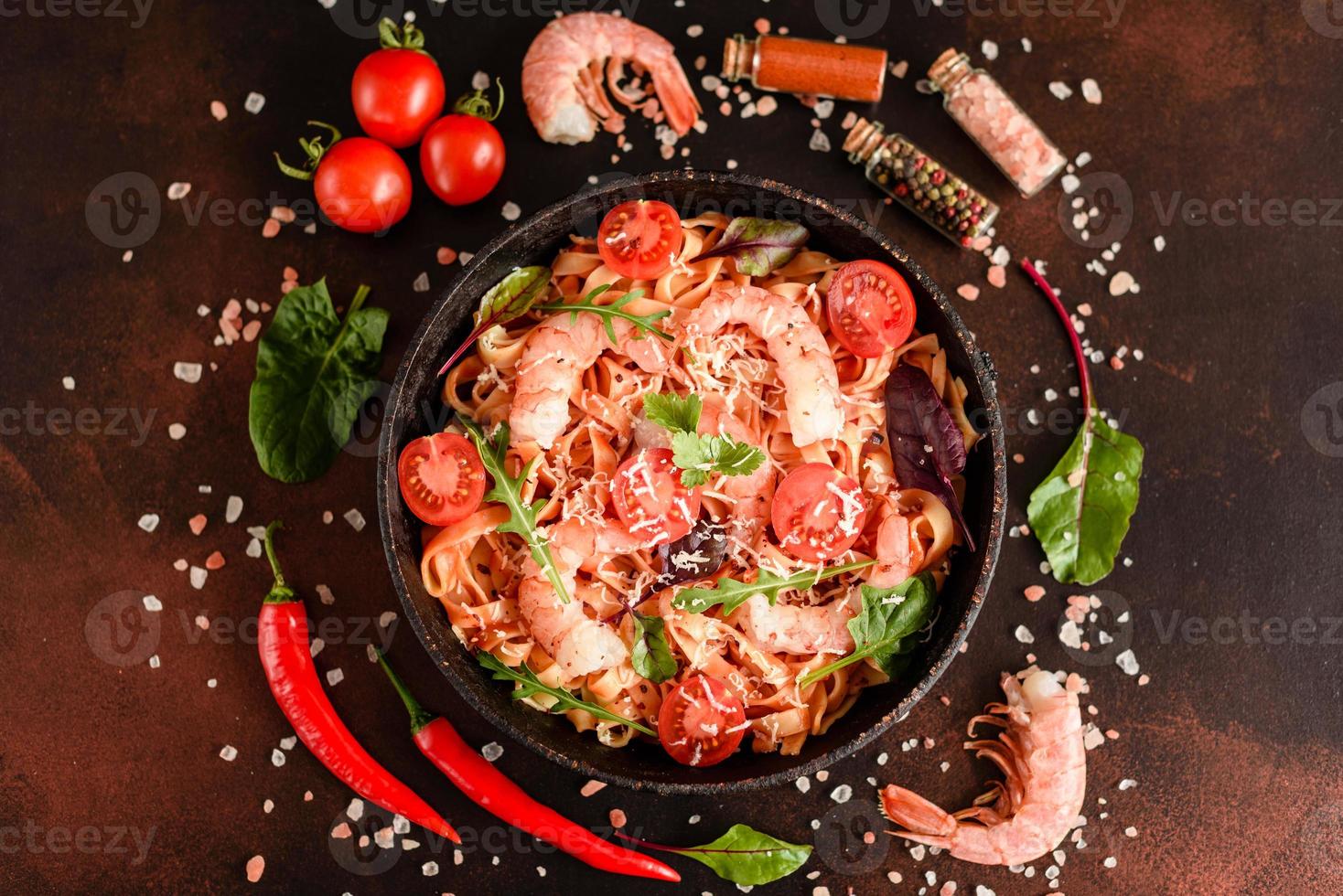 Lekkere pasta met garnalen en tomaat op een koekenpan foto