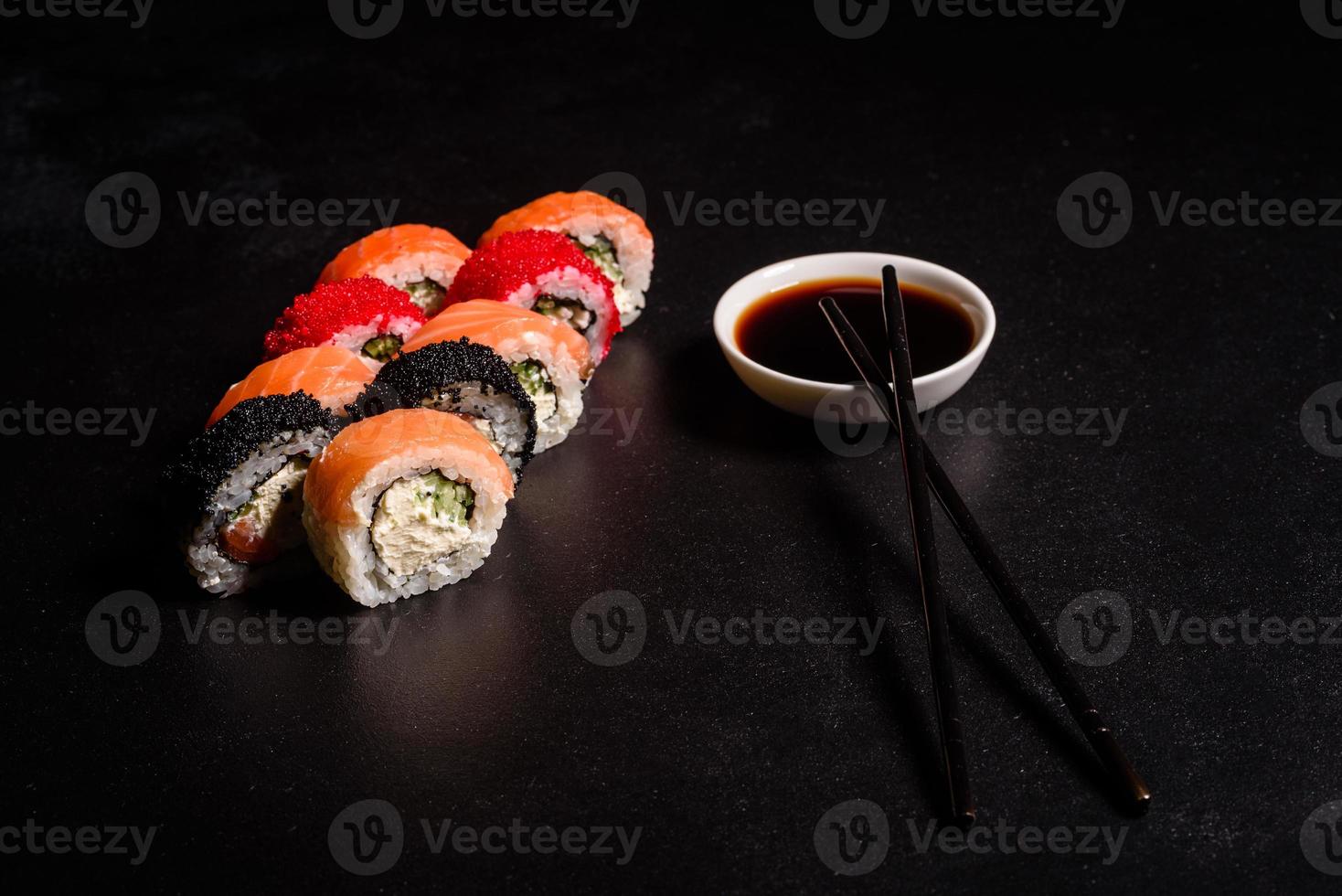 verschillende soorten sushi geserveerd op een donkere achtergrond foto