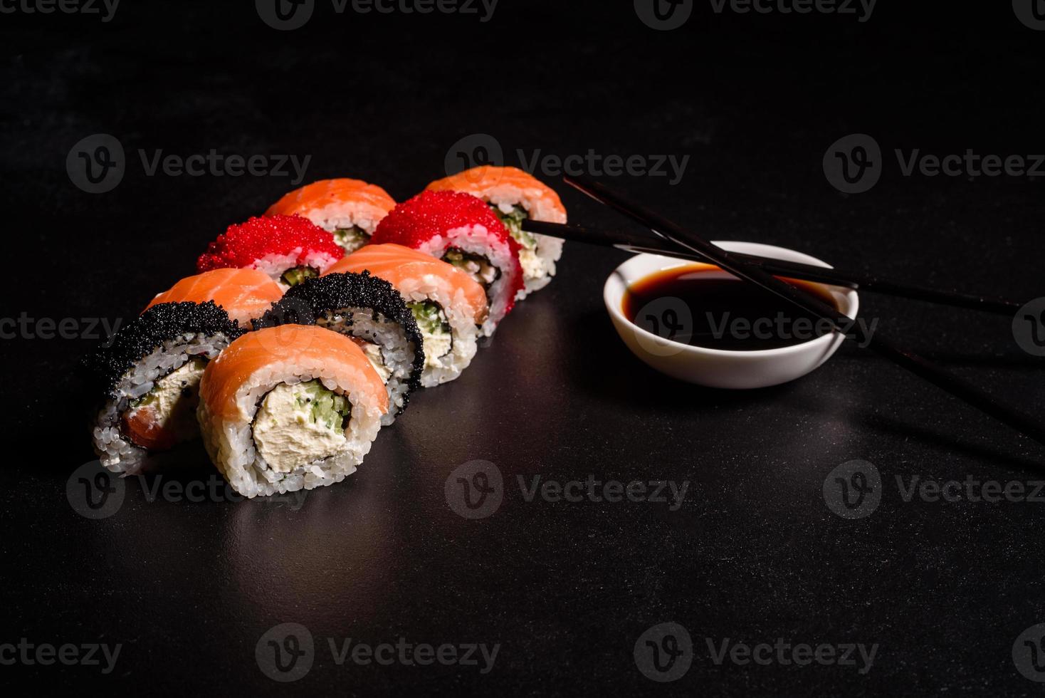 verschillende soorten sushi geserveerd op een donkere achtergrond foto