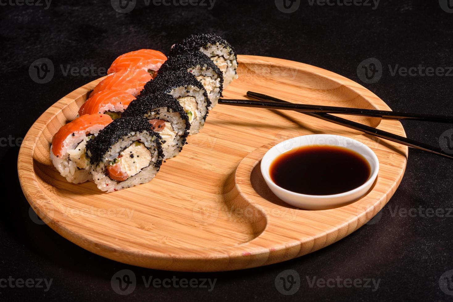 verschillende soorten sushi geserveerd op een donkere achtergrond foto