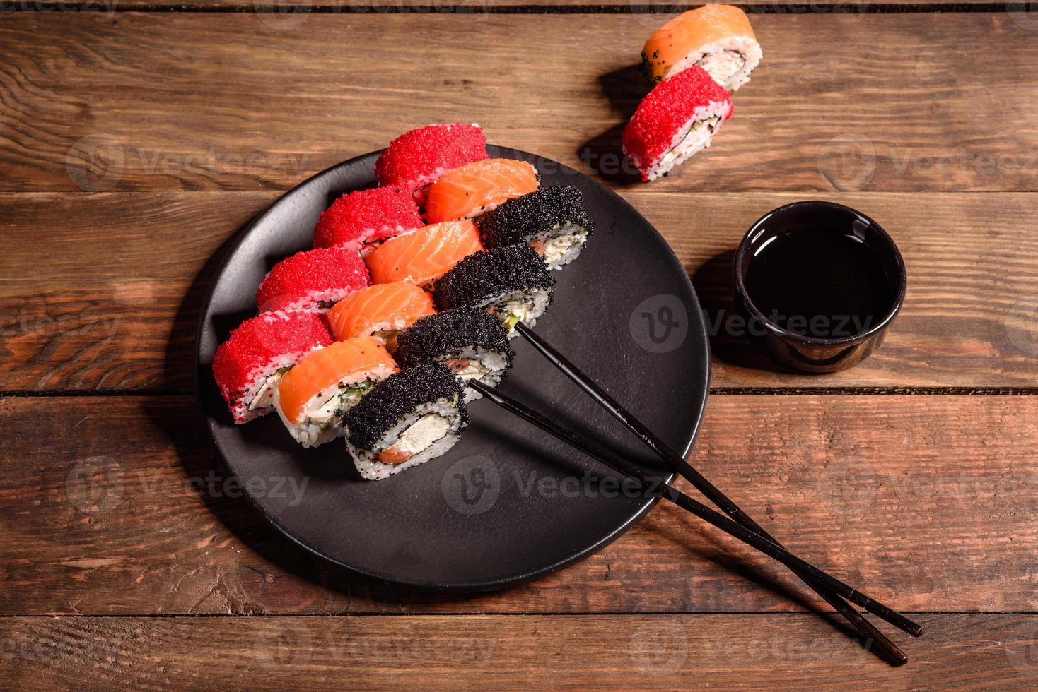 verschillende soorten sushi geserveerd op een donkere achtergrond foto