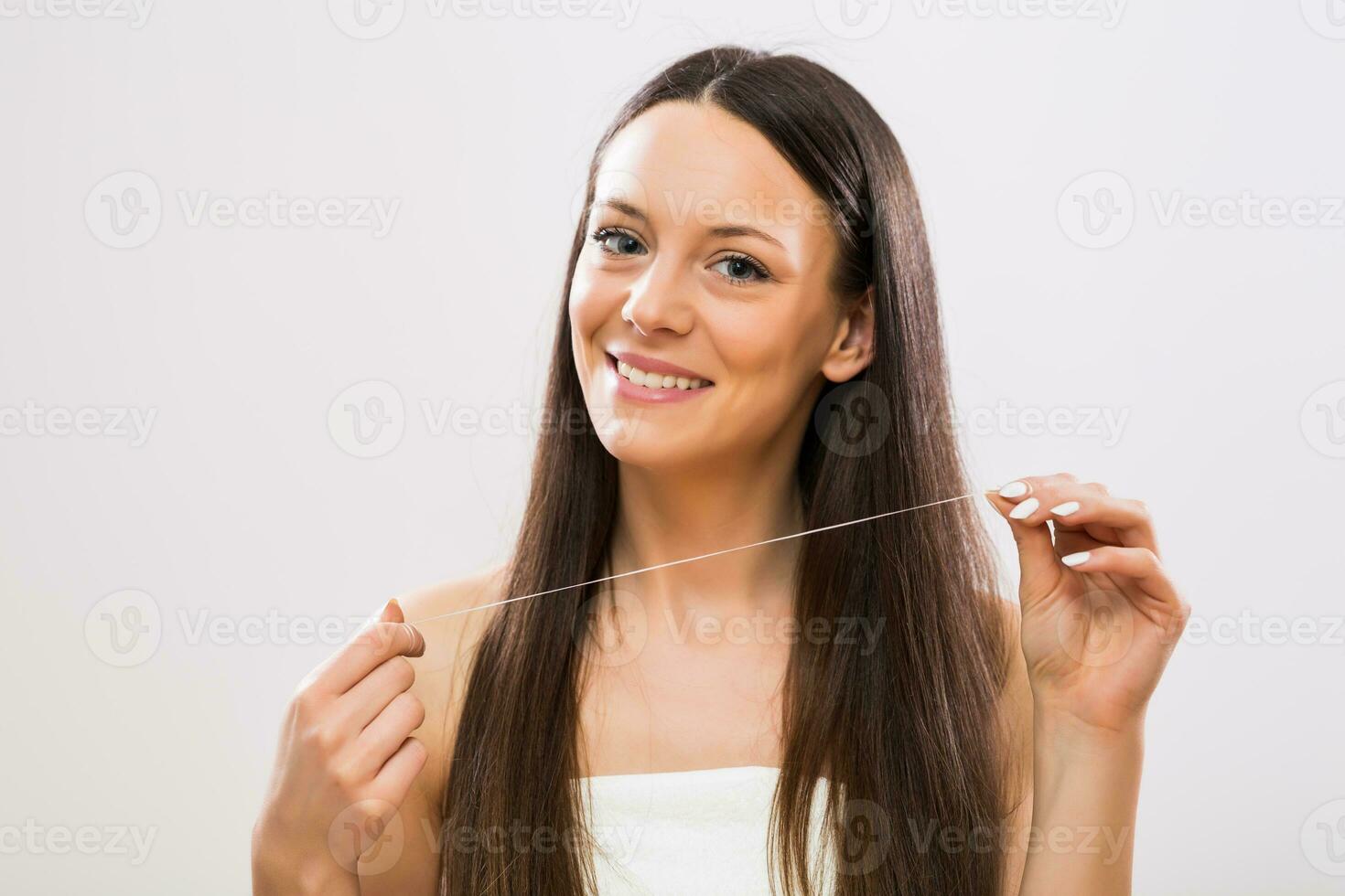 beeld van mooi brunette vrouw tonen tandheelkundig floss foto