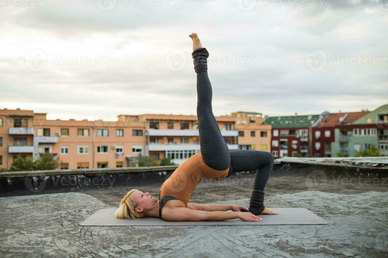 vrouw beoefenen yoga Aan de dak foto