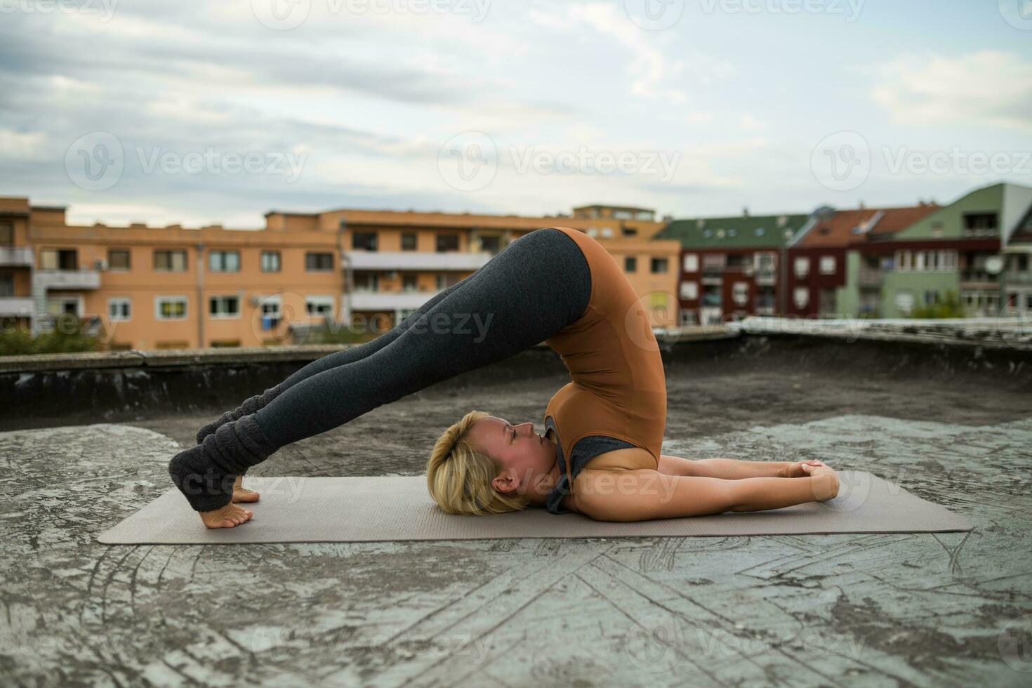 vrouw beoefenen yoga Aan de dak foto