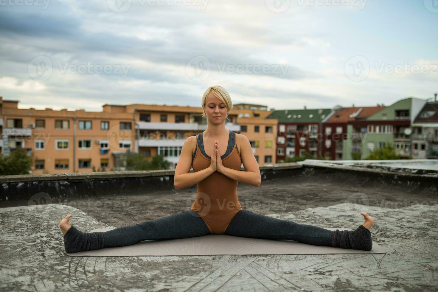 vrouw beoefenen yoga Aan de dak foto