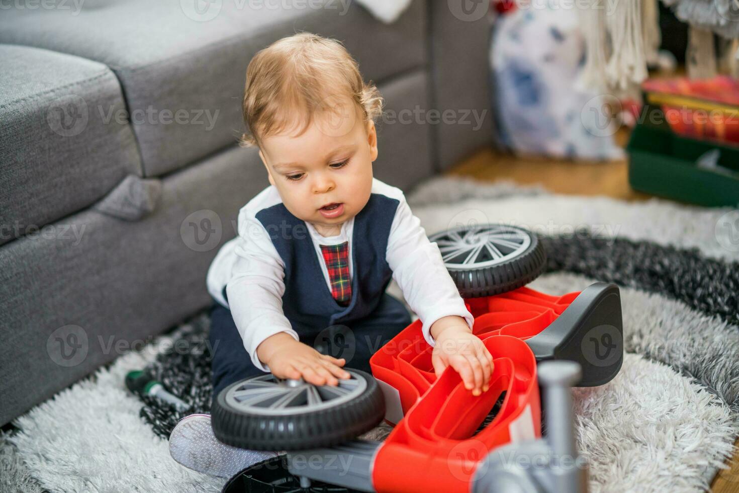 schattig weinig baby jongen spelen en repareren zijn eerste fiets foto