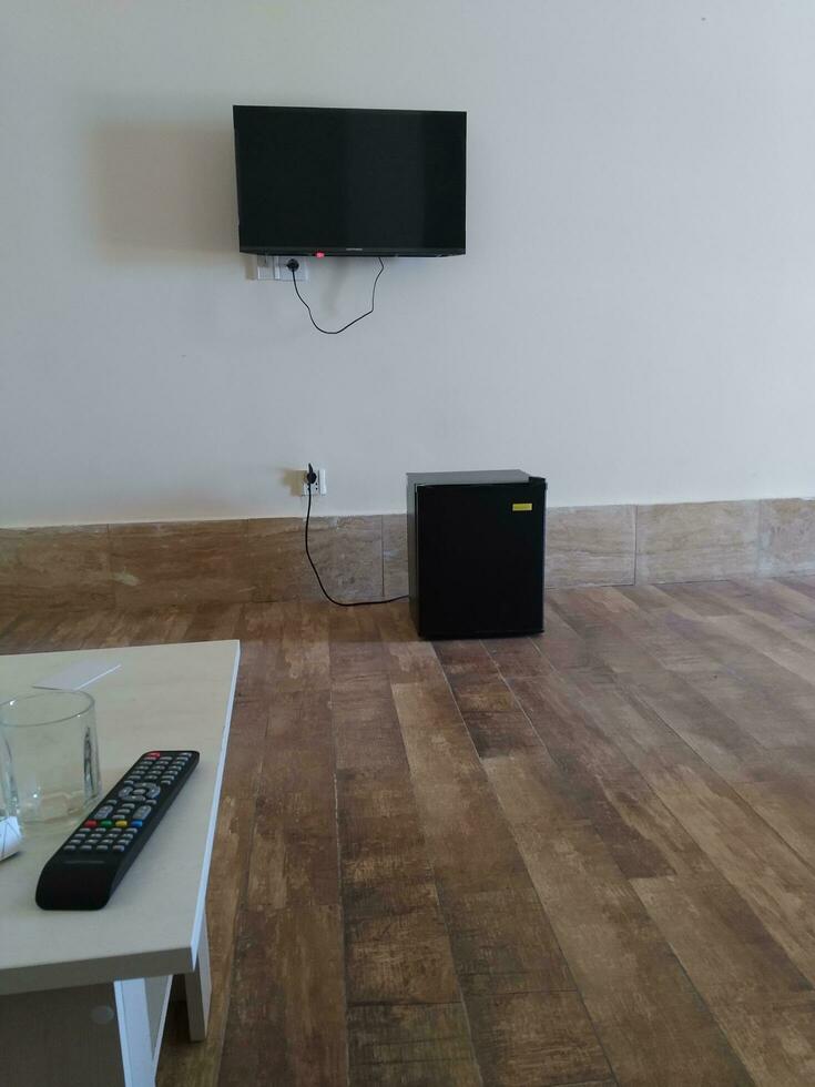 TV afgelegen controle in modern leven kamer met parket verdieping en wit muur foto