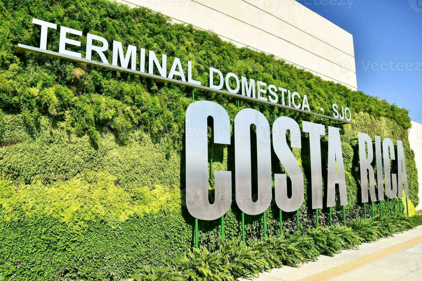 de teken voor de terminal costa rica tegen groen planten foto