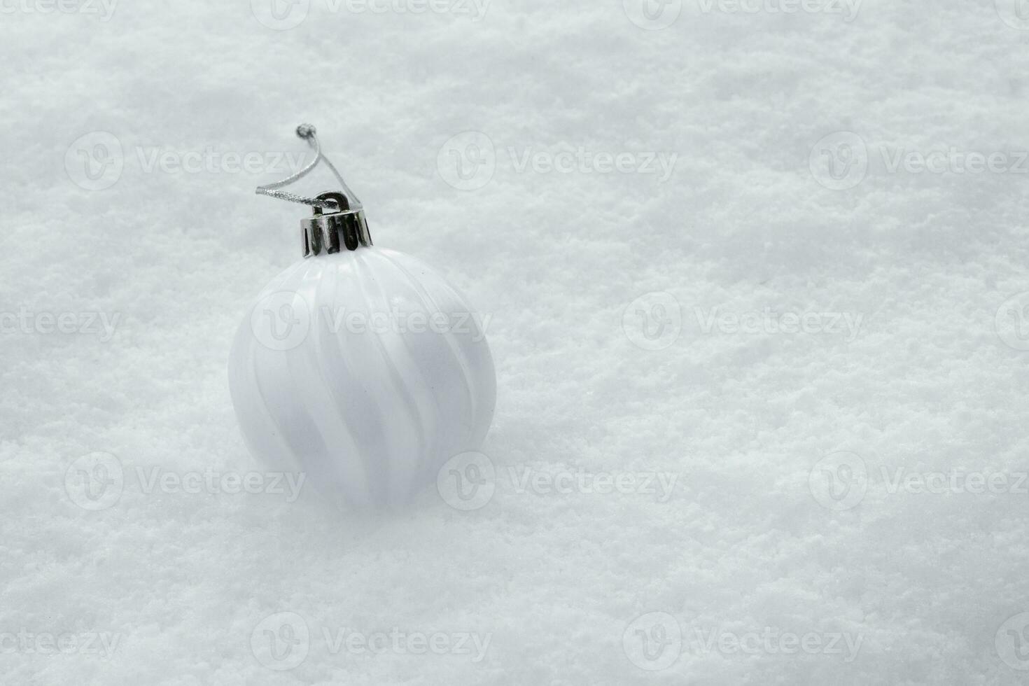 wit bal met Kerstmis boom leugens Aan zuiver sneeuw. hoog kwaliteit foto