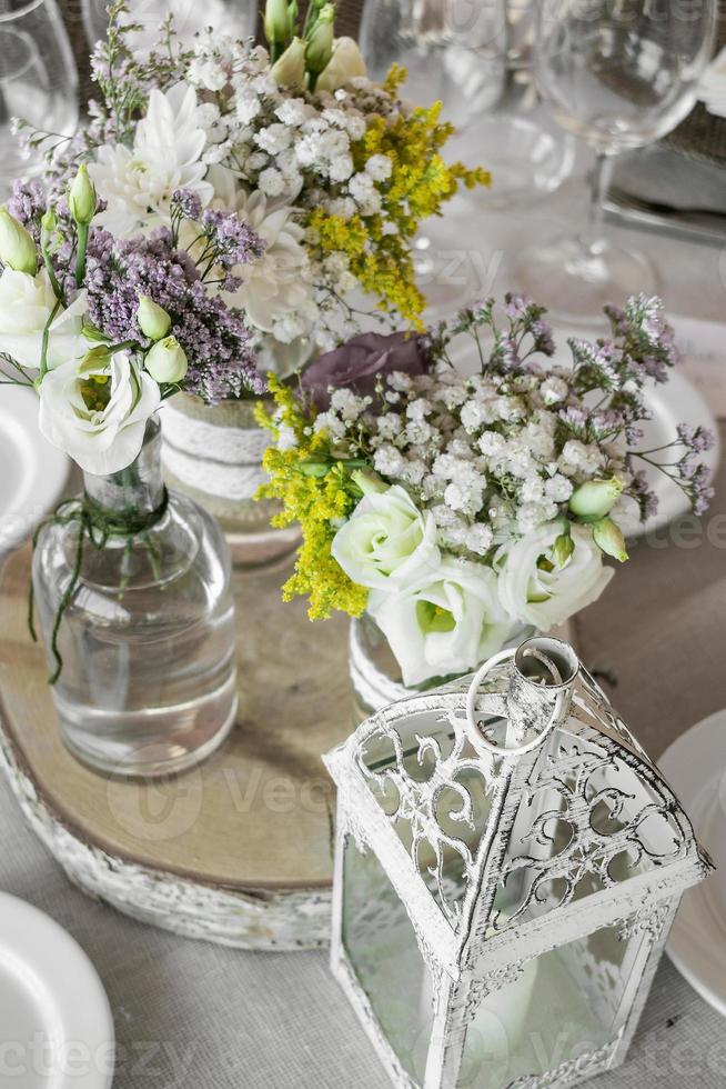 bloemenarrangement en decoratie rustiek interieur in trouwtafel foto