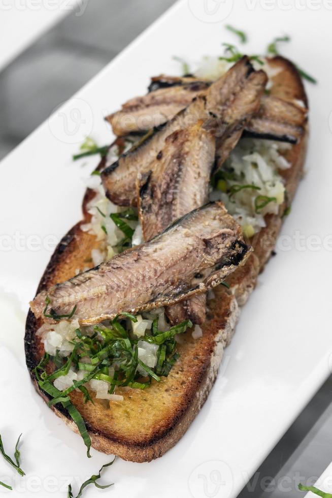 portugese tiborna open toast sandwich tapas met sardine en ui knoflook foto