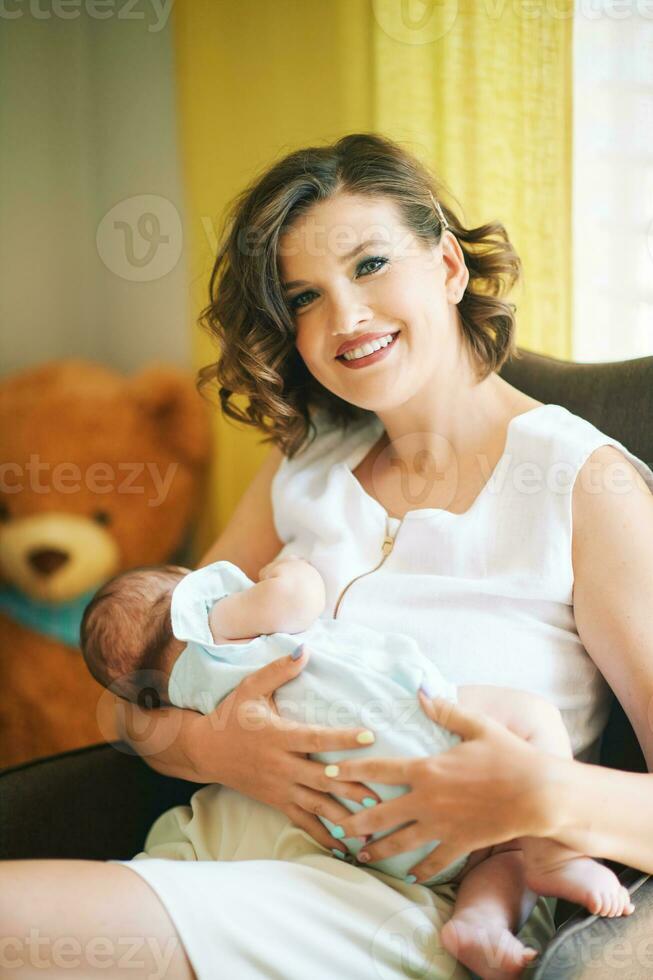 binnen- portret van jong mooi moeder borstvoeding geeft baby foto