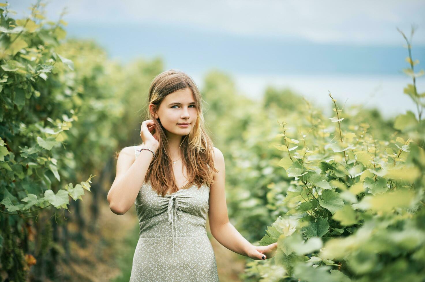 buitenshuis portret van mooi jong tiener meisje wandelen in wijngaarden, zomer activiteiten foto
