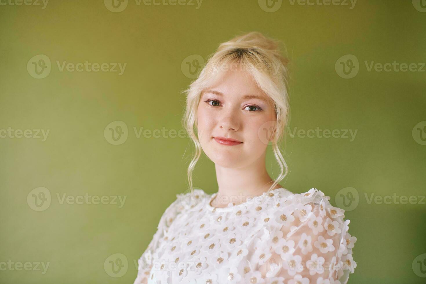 schoonheid portret van mooi jong 15 - 16 jaar oud tiener meisje vervelend wit jurk poseren Aan groen achtergrond foto