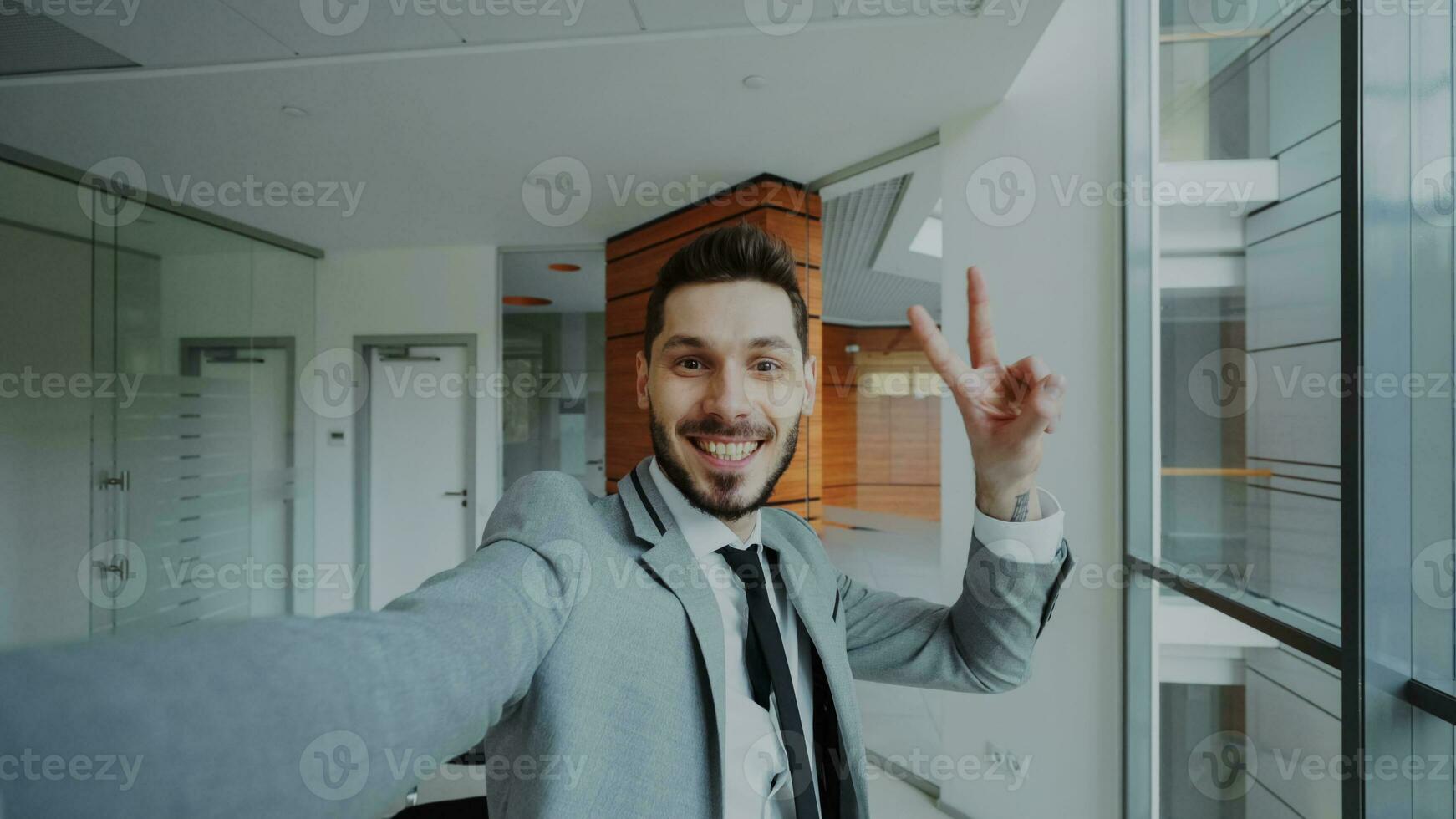 pov van jong zakenman in pak nemen een selfie foto en hebben pret in modern kantoor binnenshuis