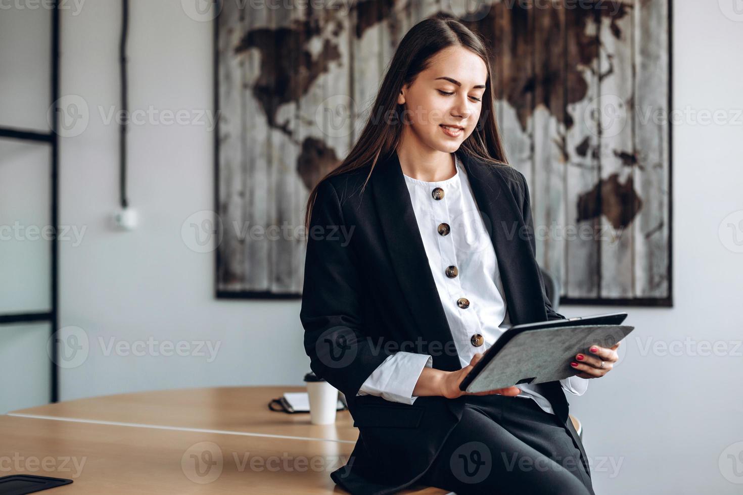 zakenvrouwen die aan een tablet werken, verspreiden zich op een bureau, op kantoor foto