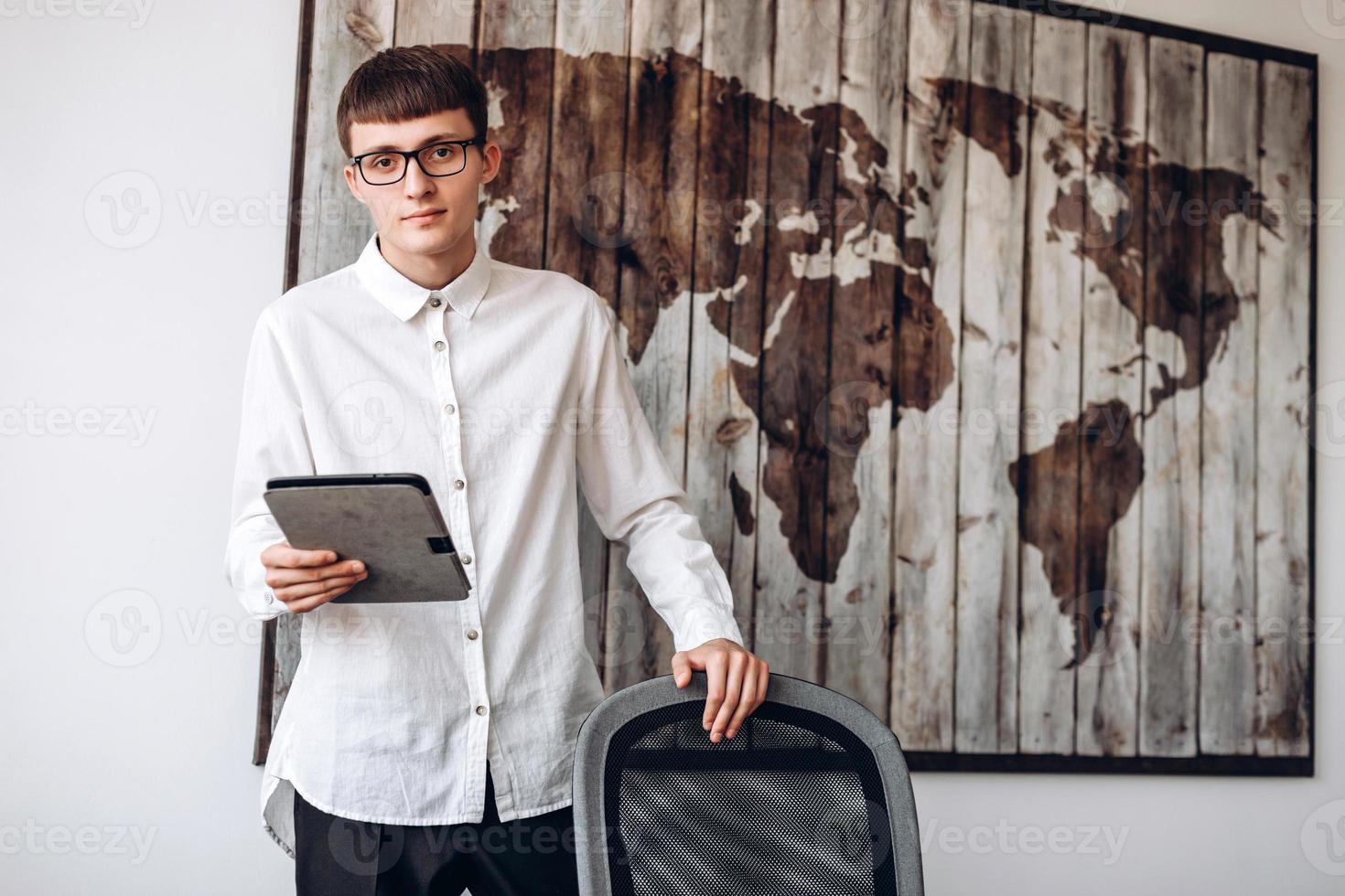 jonge, gerichte zakenman in glazen heeft een tablet. kantoor werk concept foto