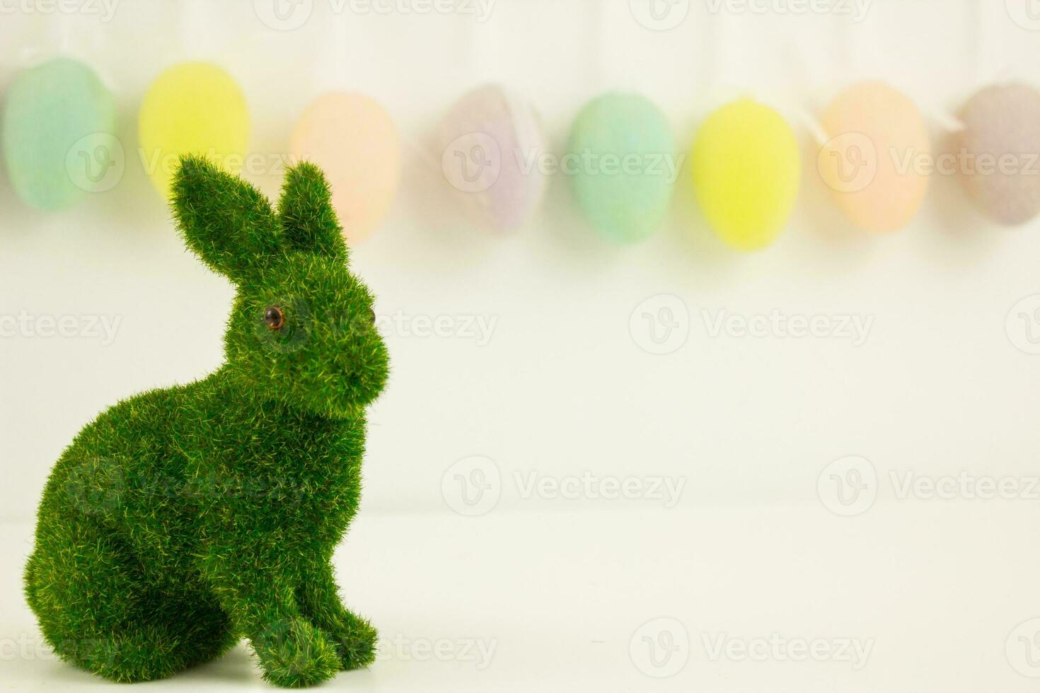 groen Pasen konijn Aan een achtergrond van slingers van decoratief eieren. foto