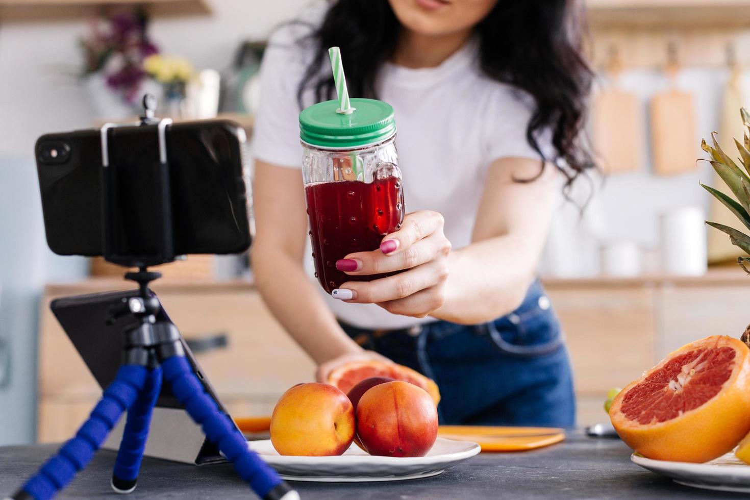 gelukkige jonge vrouw die smakelijke voedzame smoothie bereidt foto