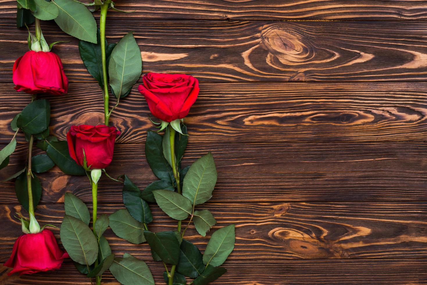 op een houten ondergrond staan rode rozen foto
