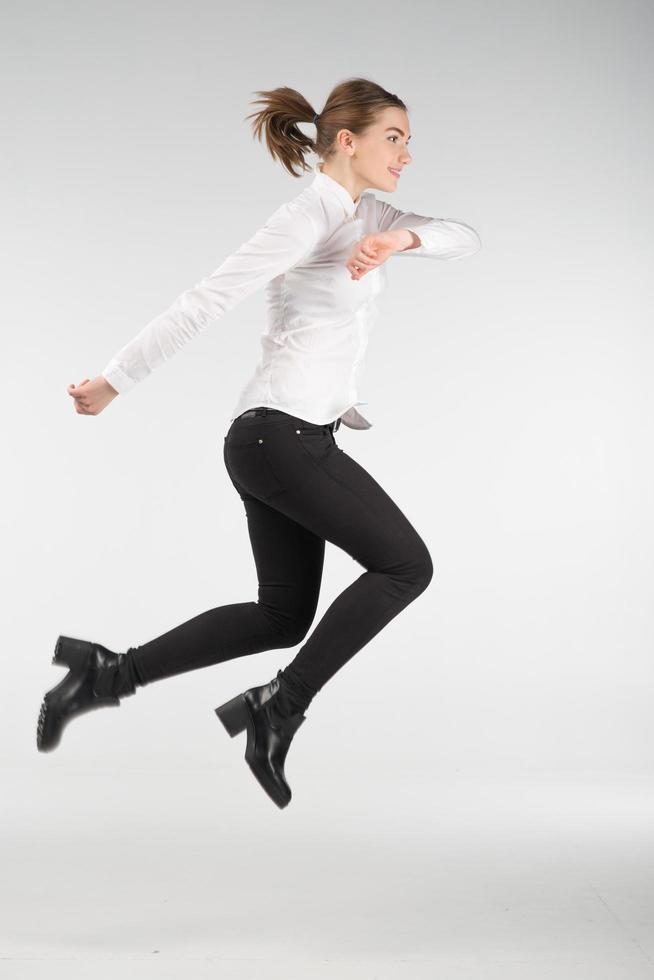 gelukkig lachende jonge vrouw springen in de lucht - mensen concept afbeelding foto