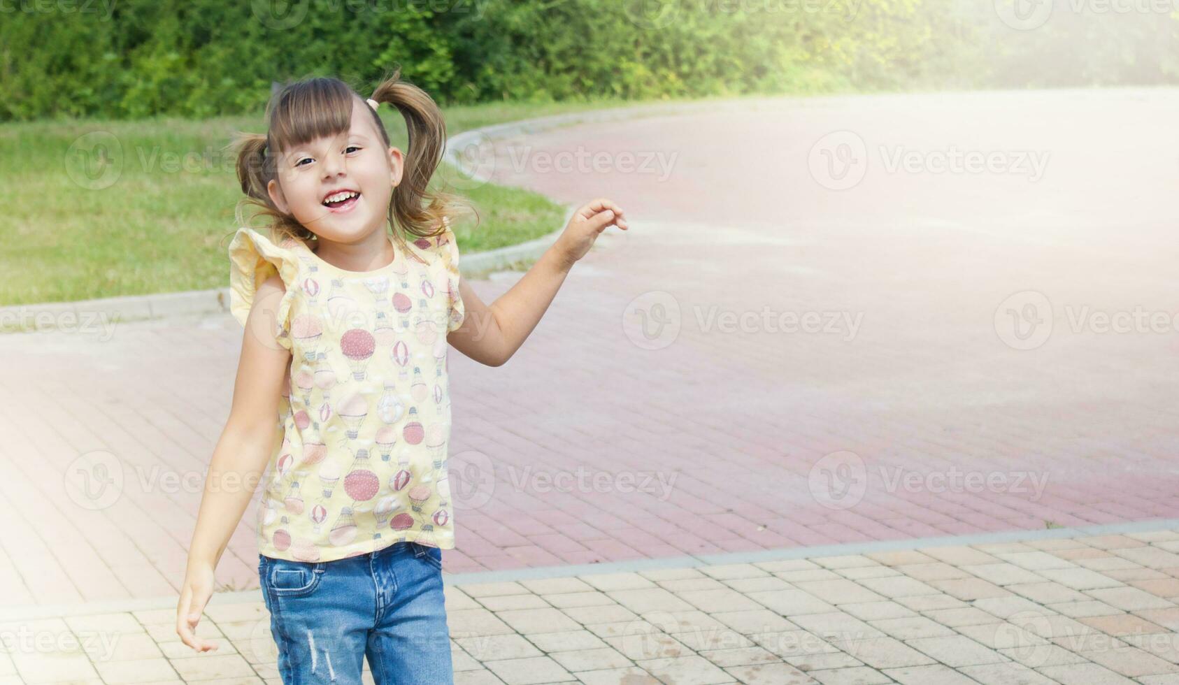 weinig gelukkig jumping meisje. gelukkig kind Aan de straat. buitenshuis spellen foto